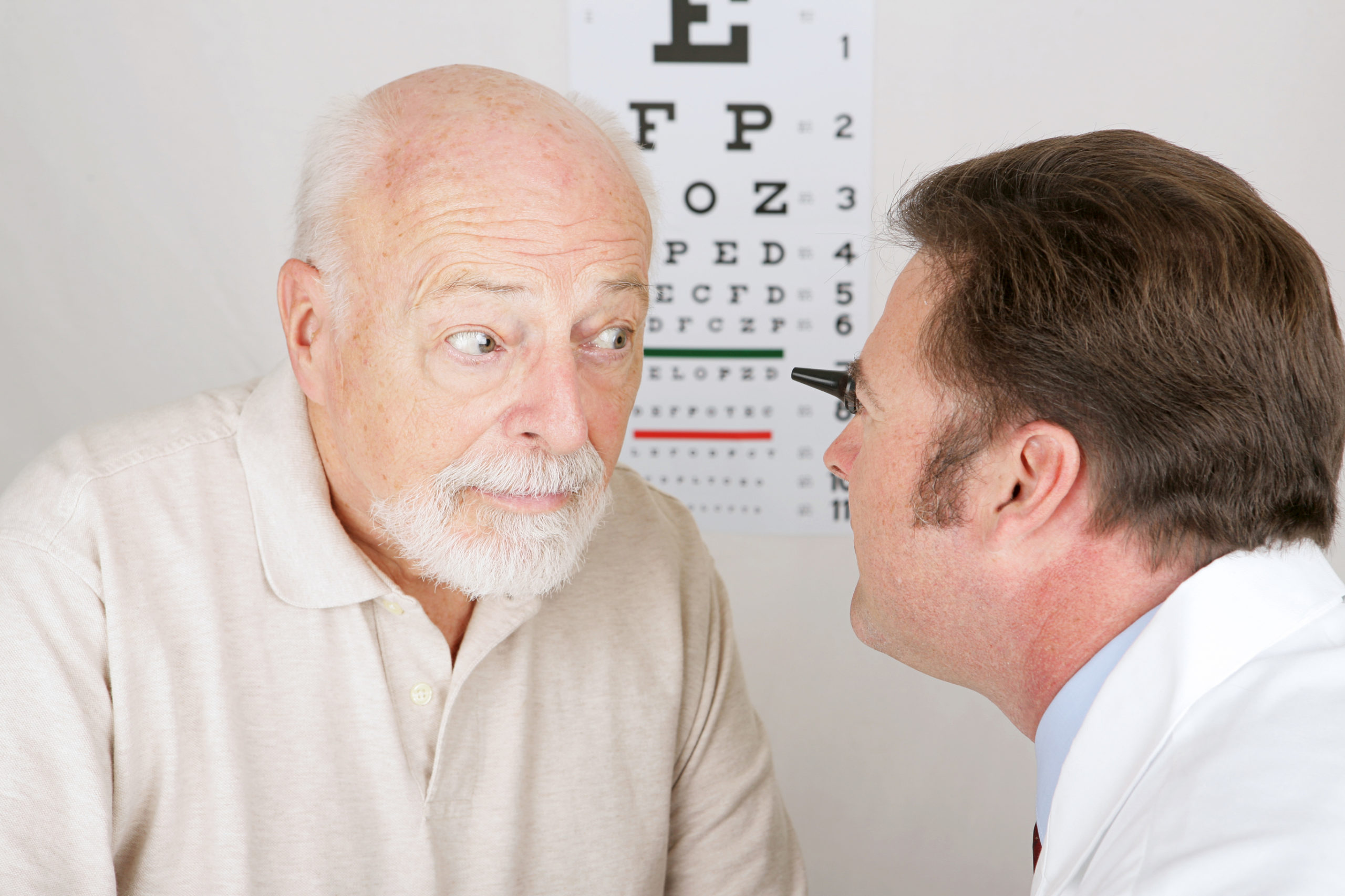 senior man getting eyes examined by eye doctor